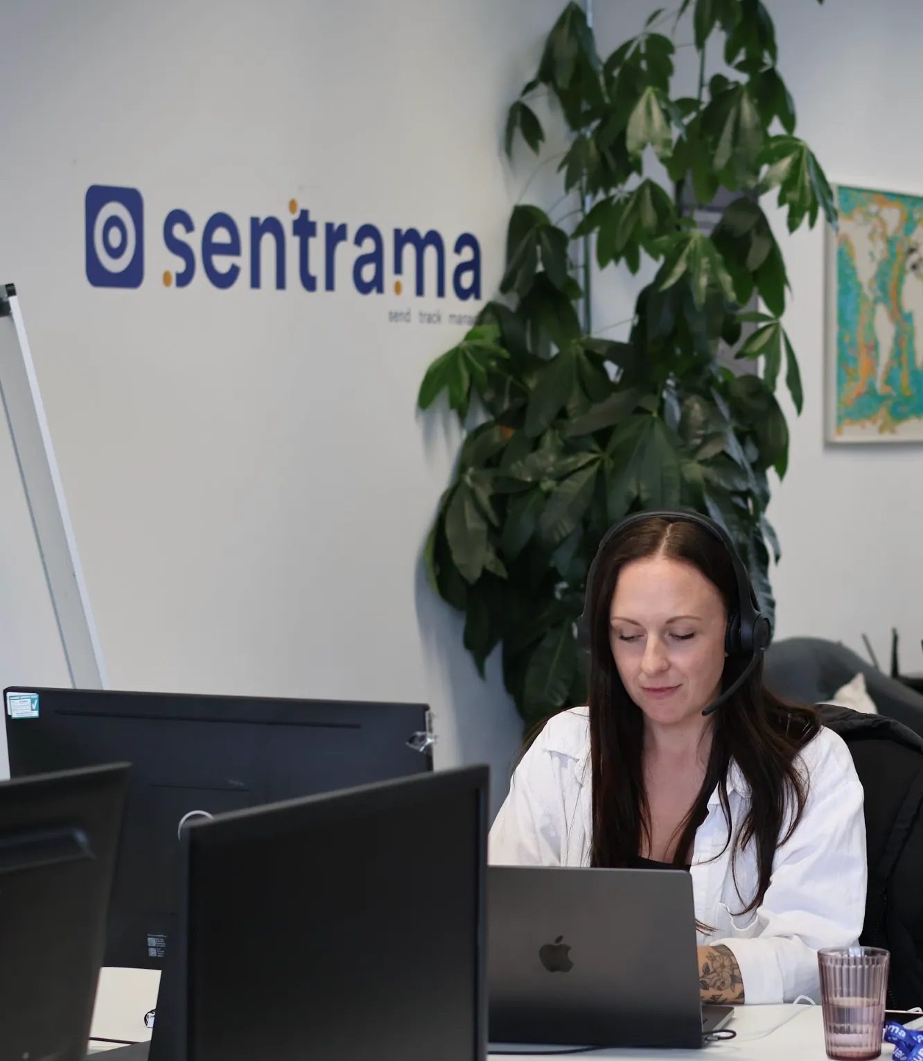A Sentrama SDR taking a call at her desk beneath the Sentrama office sign